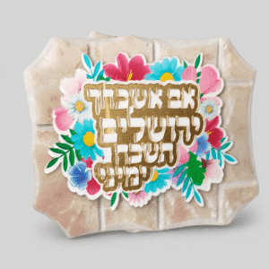 לוח אבן עומד עם זר פרחים צבעוני והפסוק אם אשכחך ירושלים בזהב