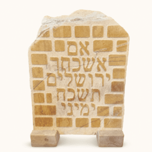 לוח אבן עומד עם הכיתוב אם אשכחך ירושלים תשכח ימיני על רקע אבני הכותל המערבי