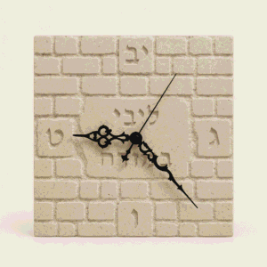 שעון קיר ליבי במזרח מאבן עם שעות באותיות עבריות ומחוגים שחורים מעוטרים
